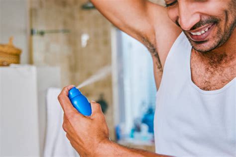 Una donna che applica un deodorante spray sulle ascelle
