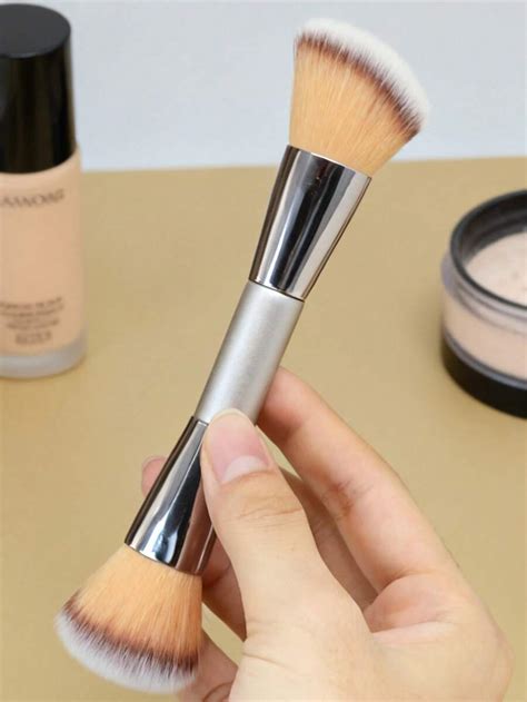 Pennello da trucco che applica cipria su una gamba con smagliature coperte