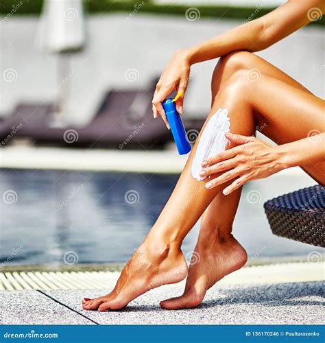 Donna che applica autoabbronzante sulle gambe con un batuffolo di cotone