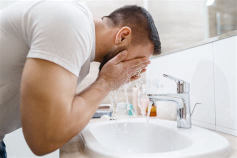 uomo che si lava il viso