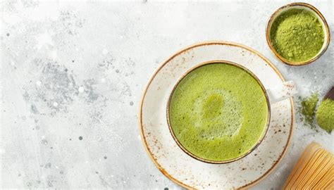 tazza di tè matcha verde vibrante e foglie di tè