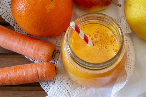 Immagine di un bicchiere di centrifugato colorato con frutta e verdura fresca attorno