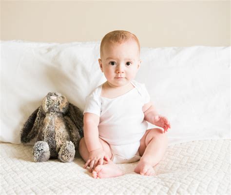 Bambino di 7 mesi in posizione seduta assistita