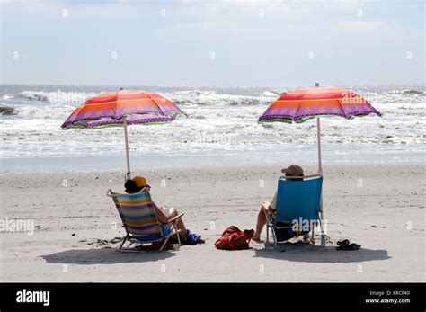 Immagine di una spiaggia con ombrelloni e persone che si rilassano